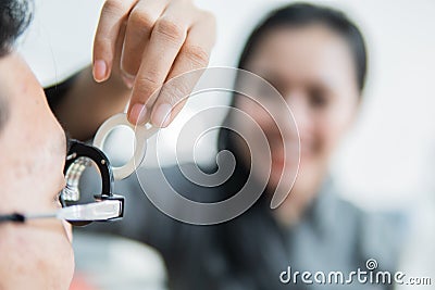 a female ophthalmologist on a trial frame when with the patient Stock Photo