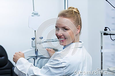 Female optometrist adjusting phoropter Stock Photo