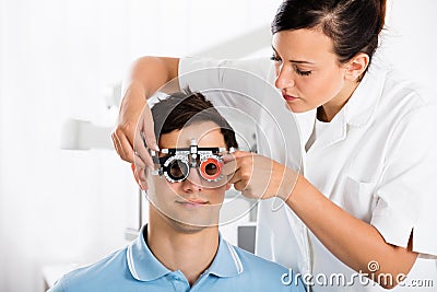 Female Optometrist Checking Patient`s Vision With Trial Frame Stock Photo