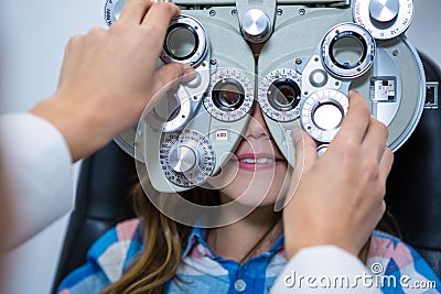 Female optometrist examining young patient on phoropter Stock Photo