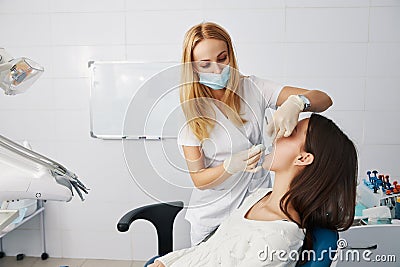 Dentist putting putty stone into patient mouth for dental impression Stock Photo