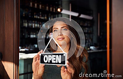 Female Owner Of Start Up Coffee Shop Or Restaurant Turning Round Open Sign On Door Stock Photo