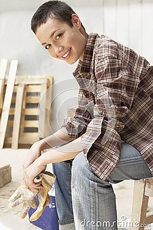 Female Painter Holding Gloves On Work Break Stock Photo