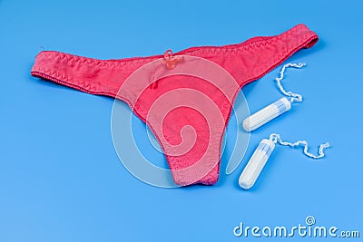 Female panty and tampons isolated on a blue background. Woman hygiene Stock Photo