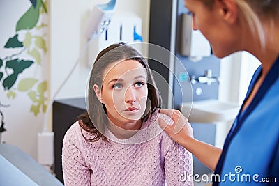 Female Patient Being Reassured By Nurse In Hospital Room Stock Photo