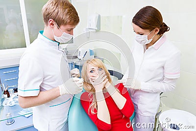 Female patient in dentist office afraid of doctor, procedure Stock Photo