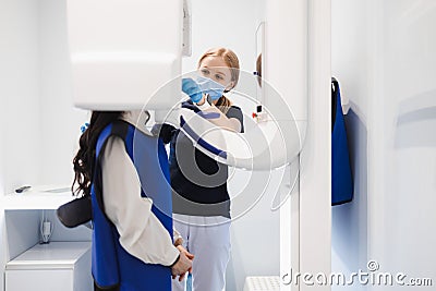 Female patient make a dental computer tomograph. The radiologist makes a CT scan of the jaw. Stock Photo