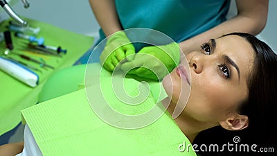 Female patient waiting for teeth polishing procedure in chair, regular check-up Stock Photo