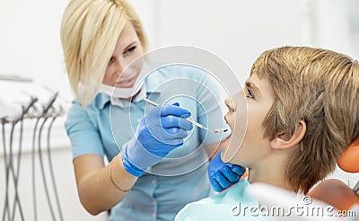 Female Pediatric Dentist Putting a Mouth Mirror in Stock Photo