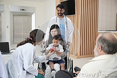 Female pediatric doctor teasing boy for examination at hospital. Stock Photo