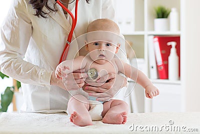 Female pediatrician examining heartbeat of baby with stethoscope Stock Photo