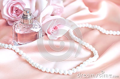Female perfume bottle, rose, pearls on pink silk Stock Photo