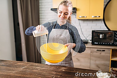 Female person adds cream into a bowl, cake cooking Stock Photo