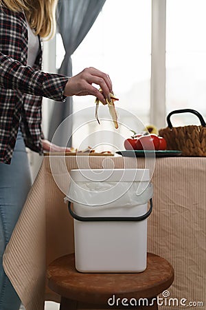 Female person recycling food leftovers in a compost bin. Woman cooking at home and throwing compostable organic waste in a bokashi Stock Photo