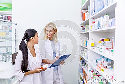 female pharmacists with medication and clipboard working together Stock Photo