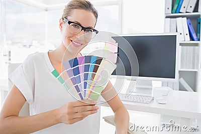 Female photo editor holding colors in office Stock Photo