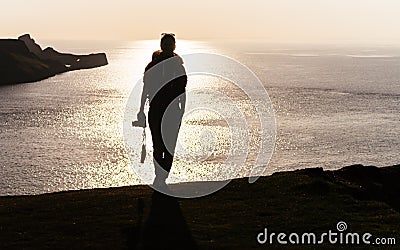 Female photographer backpacker silhouette front shot on top of m Stock Photo