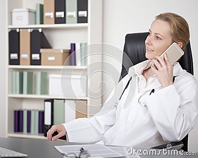 Female Physician on Chair Calling on Mobile Phone Stock Photo