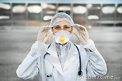 Female physician walking in uniform on front line,fighting viral outbreak.Private protective equipment PPE.Quarantined area Stock Photo