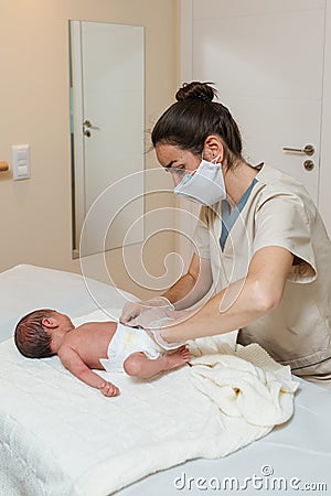 Female physiotherapist performing a visceral-digestive assessment on a newborn baby. Stock Photo