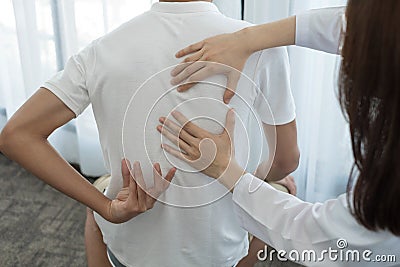 Female physiotherapists provide physical assistance to male patients with back injuries back massages for relaxation and muscle Stock Photo