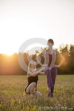 Female pilates trainer making corrections to her trainee as they Stock Photo
