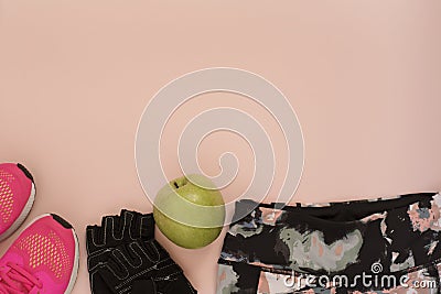 Female pink sneakers, sport shoes, leggings, green apple and gloves in flat lay style, top view. Fitness concept, active lifestyle Stock Photo