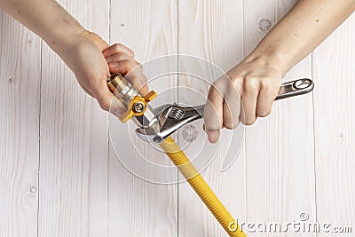 Female plumber connecting gas hose to gas stopcock. Stock Photo