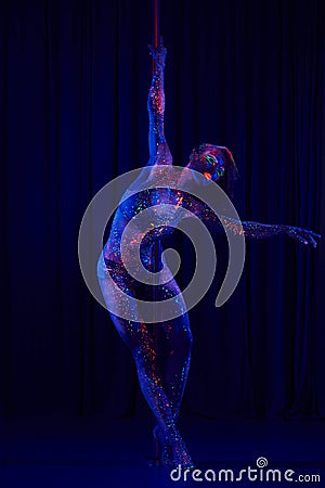 Female pole dancer in bright neon colours under ultraviolet Stock Photo