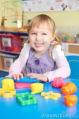 Female Pre School Pupil Playing With Modelling Clay Stock Photo