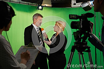 Female Presenter Interviewing In Television Studio With Crew In Stock Photo
