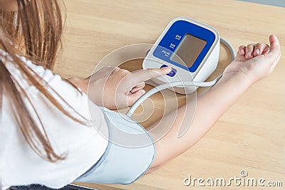Female press start button on blood pressure Stock Photo