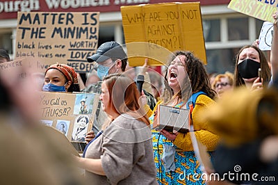 A Female protester screaming at a Black Lives Matter protest. Surrounded by other protesters who wear PPE Face Masks Editorial Stock Photo