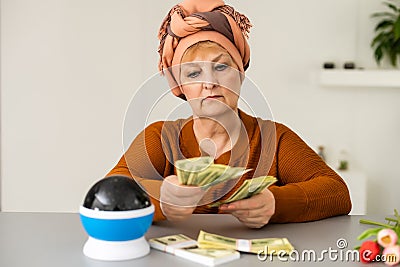 Female psychic or fortune teller gesturing with her hands indicating money Stock Photo