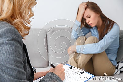 Female psychologyst therapy session with client indoors sitting fulfilling medical form Stock Photo