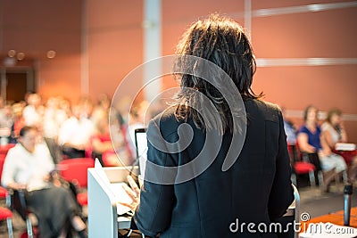 Female public speaker giving talk at Business Event. Stock Photo