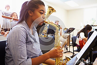 Female Pupil Playing Saxophone In High School Orchestra Stock Photo