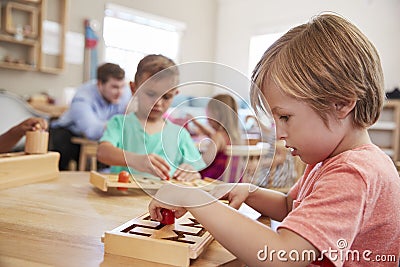 Female Pupil Working At Table In Montessori School Stock Photo