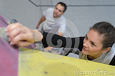 Female reaching grip on climbing wall Stock Photo