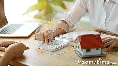 A female real estate agent estimates housing costs for a new client Stock Photo