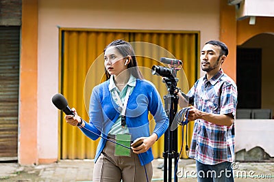 a female reporter hunting for news with a cameraman Stock Photo
