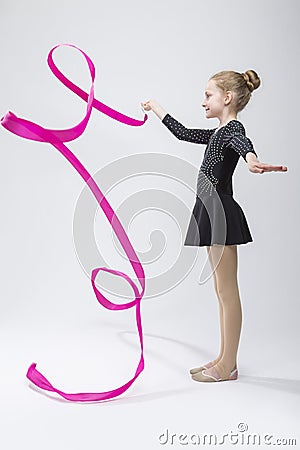 Female Rhythmic Gymnast In Professional Competitive Black Sparkling Starry Suit Doing Artistic Ribbon Spirals Exercises Stock Photo