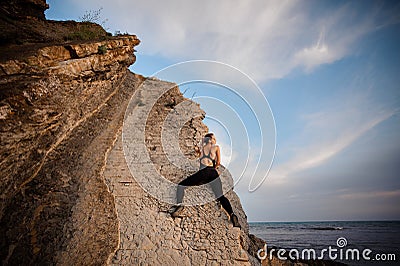 Female rock climber climbs on rocky wall Stock Photo