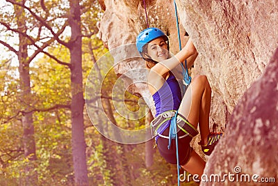 Female rock climber trying to climb the cliff Stock Photo