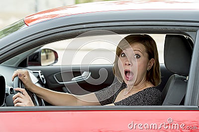 Female rookie new driver young beautiful woman scared and stressed while driving car in fear and shock Stock Photo