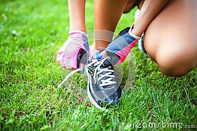 Female runner and athlete preparing shoes for jogging Stock Photo