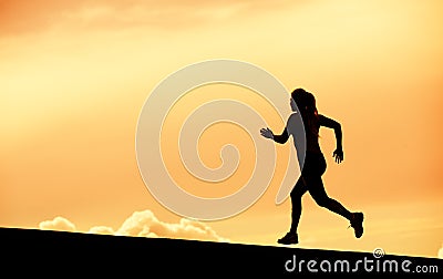 Female runner silhouette, running into sunset Stock Photo