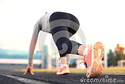 Female runner waiting for the start on the start line in stadium Stock Photo