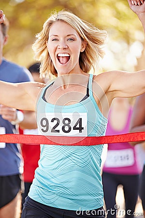 Female Runner Winning Marathon Stock Photo