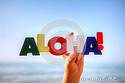 Female's hand holding colorful word 'Aloha' Stock Photo